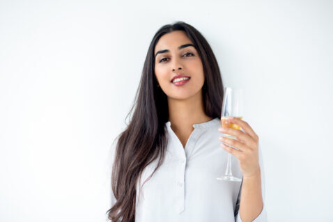 Happy Latin-American woman holding champagne flute